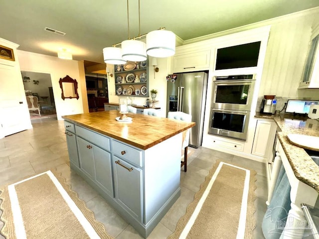 2367 Greenbrier Blvd, Pensacola, FL 32514 - kitchen featuring appliances with stainless steel finishes, butcher block countertops, pendant lighting, open shelves, and a kitchen island