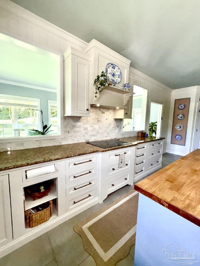 2367 Greenbrier Blvd, Pensacola, FL 32514 - kitchen with black electric cooktop, white cabinetry, ornamental molding, butcher block countertops, and backsplash