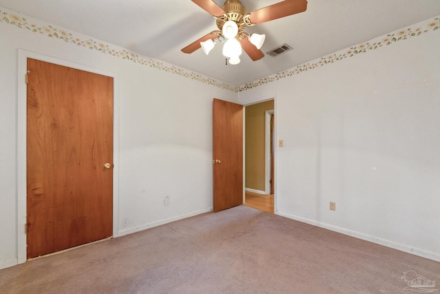 spare room featuring ceiling fan and light carpet