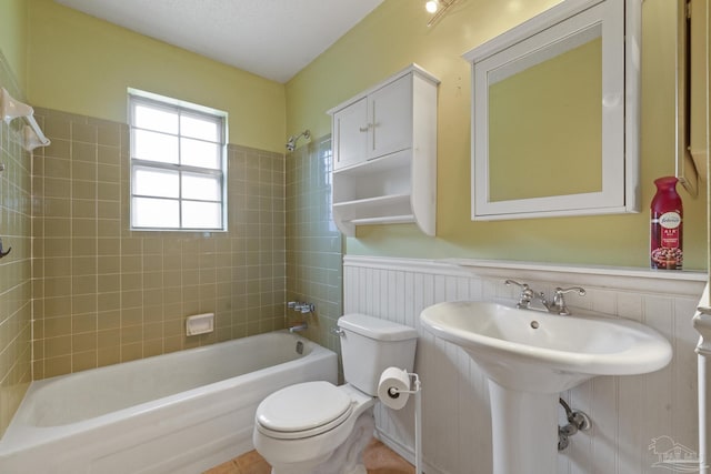 bathroom featuring toilet and tiled shower / bath