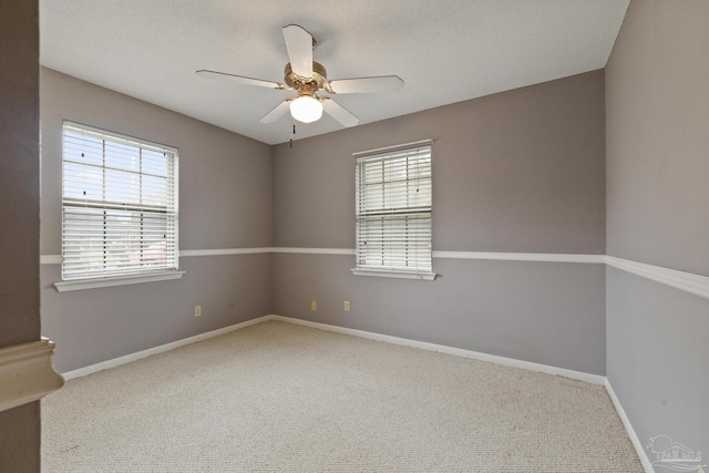 empty room featuring plenty of natural light, ceiling fan, and carpet floors