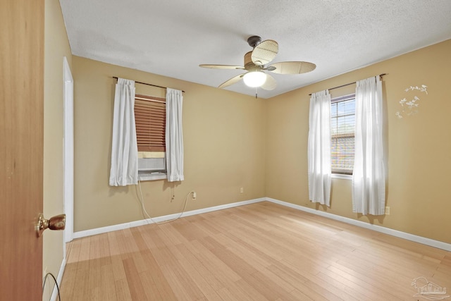 spare room with ceiling fan, light hardwood / wood-style floors, and a textured ceiling