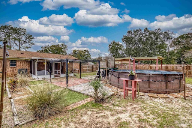 view of yard with a gazebo, a fenced in pool, and a sunroom