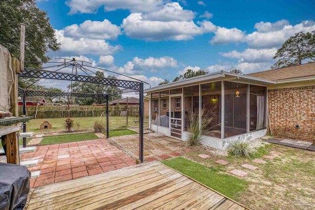 deck with a gazebo, a sunroom, a patio area, and a lawn