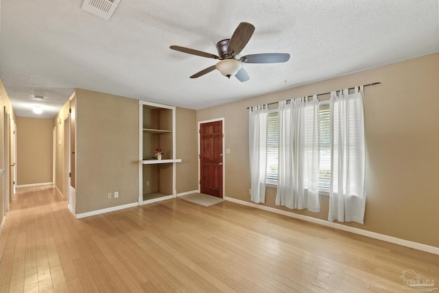 interior space with ceiling fan, light hardwood / wood-style flooring, and a textured ceiling