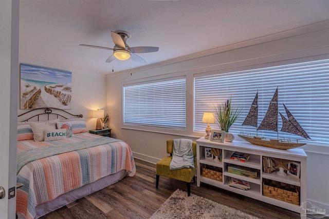 bedroom with a ceiling fan, crown molding, baseboards, and wood finished floors