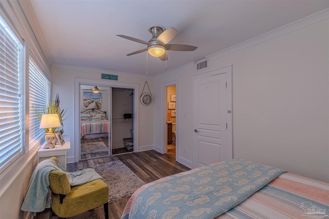 bedroom with a closet, visible vents, ornamental molding, a ceiling fan, and wood finished floors