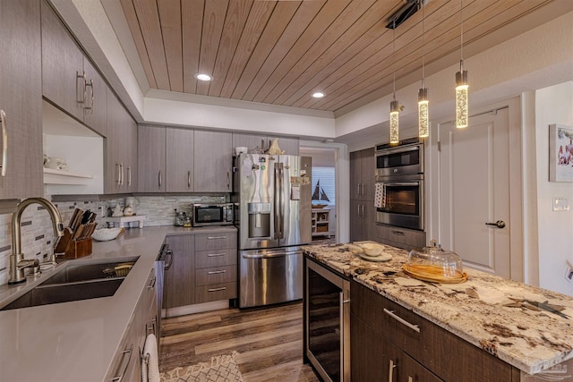 kitchen featuring wine cooler, tasteful backsplash, appliances with stainless steel finishes, a sink, and wooden ceiling