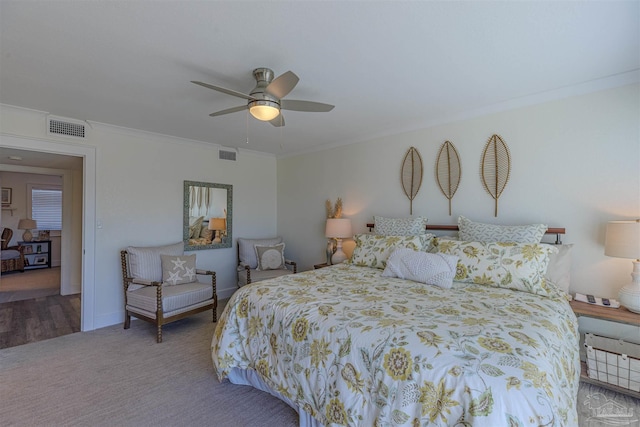 carpeted bedroom featuring visible vents, crown molding, baseboards, and ceiling fan