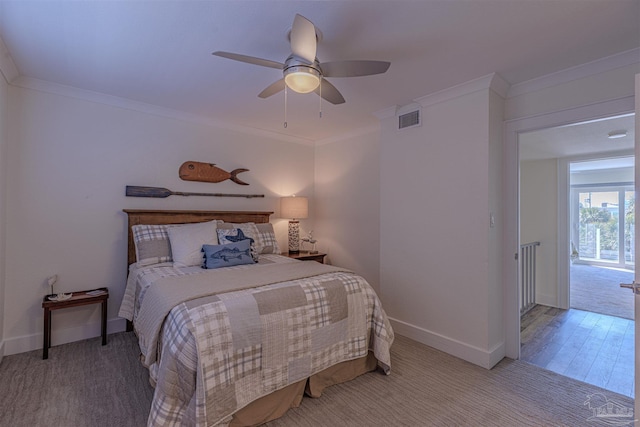 bedroom with ceiling fan, visible vents, baseboards, carpet, and crown molding