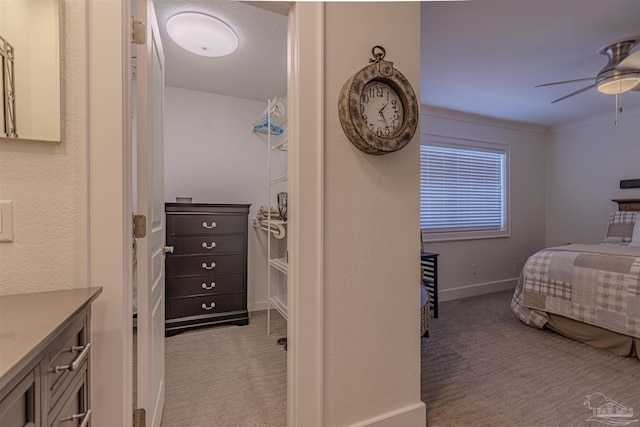 bedroom featuring light carpet, a ceiling fan, and baseboards