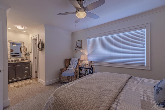 bedroom with baseboards, ceiling fan, ensuite bathroom, crown molding, and a sink