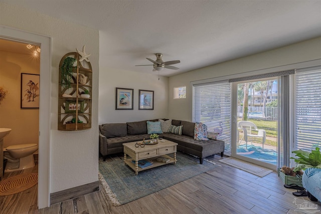 living area with ceiling fan and wood finished floors