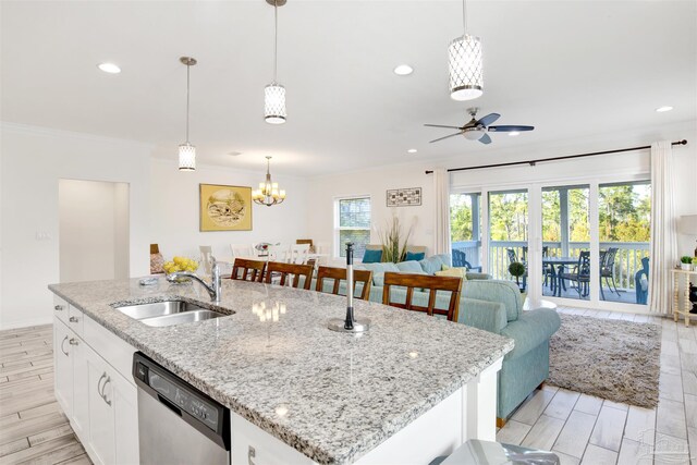 6548 Carlinga Dr, Pensacola, FL 32507 - kitchen with ornamental molding, an island with sink, stainless steel dishwasher, ceiling fan with notable chandelier, and a sink