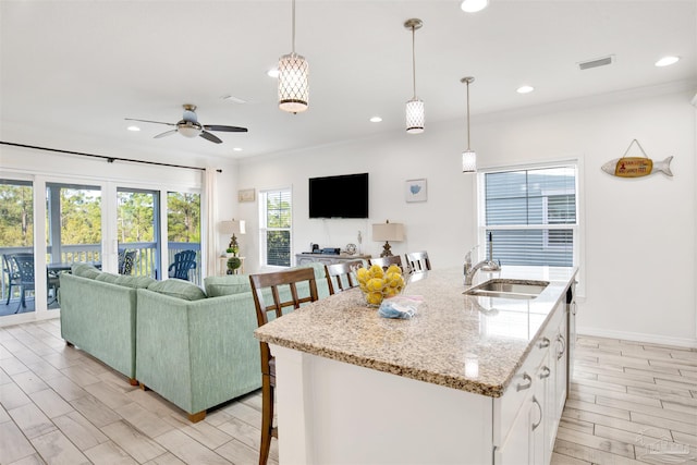 6548 Carlinga Dr, Pensacola, FL 32507 - kitchen featuring white cabinets, a sink, open floor plan, ceiling fan, and recessed lighting