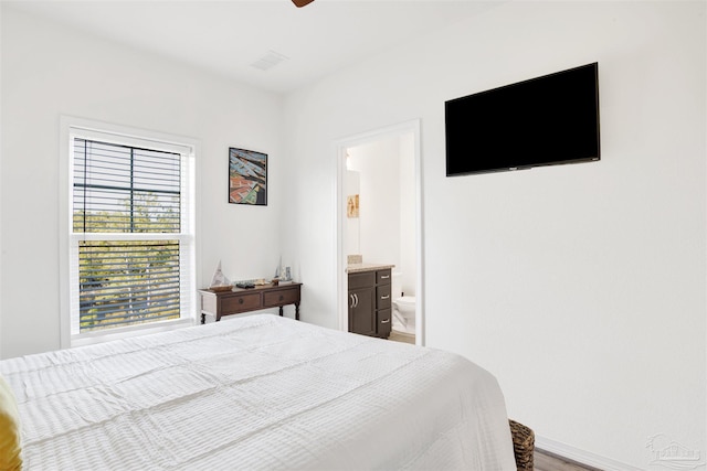 6548 Carlinga Dr, Pensacola, FL 32507 - bedroom featuring ensuite bath, a ceiling fan, visible vents, wood finished floors, and baseboards