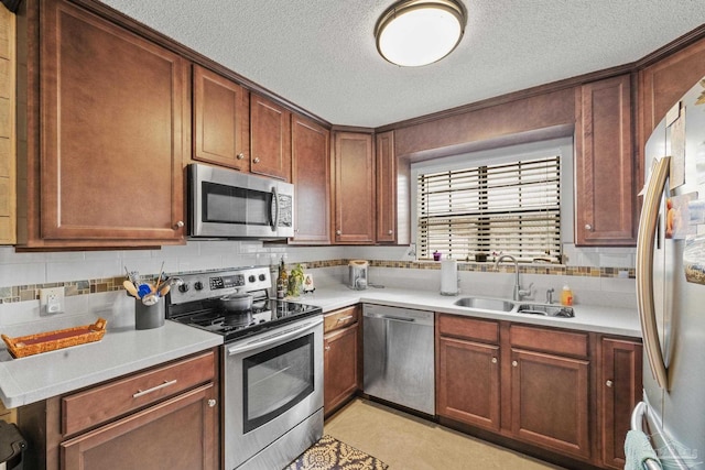 kitchen with sink, backsplash, stainless steel appliances, and a textured ceiling