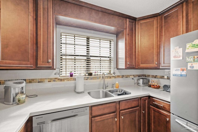 kitchen with sink, decorative backsplash, a textured ceiling, and appliances with stainless steel finishes