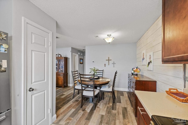 dining space featuring a textured ceiling and light wood-type flooring