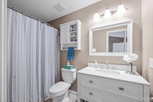 bathroom featuring vanity, toilet, and a textured ceiling