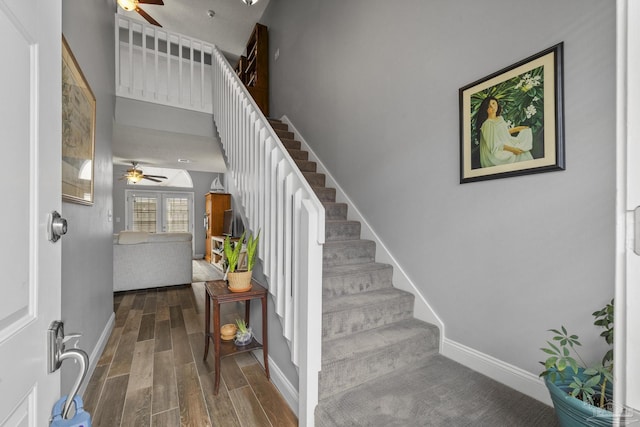 stairway featuring ceiling fan