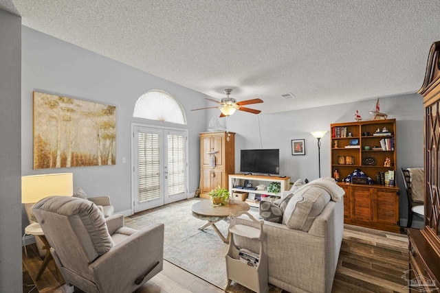 living room featuring hardwood / wood-style floors, a textured ceiling, french doors, and ceiling fan