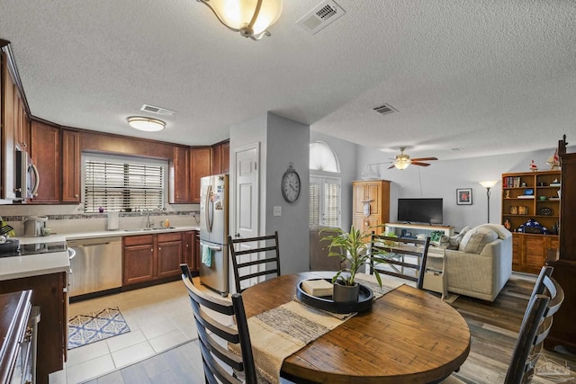 dining room with sink, a textured ceiling, and ceiling fan