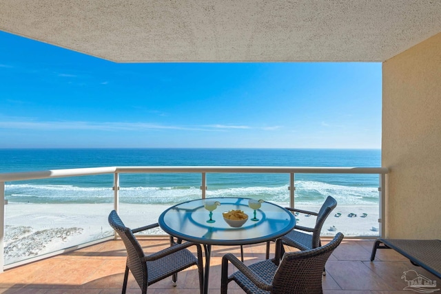 balcony featuring a water view and a beach view