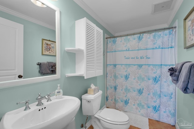 bathroom featuring ornamental molding, a shower with shower curtain, sink, and toilet