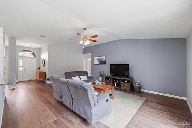 living room with hardwood / wood-style floors, ceiling fan, and lofted ceiling