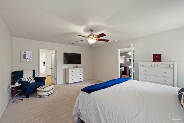 carpeted bedroom featuring ceiling fan and a textured ceiling