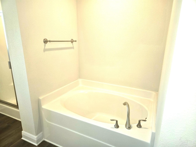 bathroom featuring a bath and wood finished floors