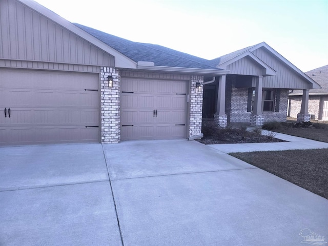 view of front of house featuring a garage, concrete driveway, brick siding, and a shingled roof