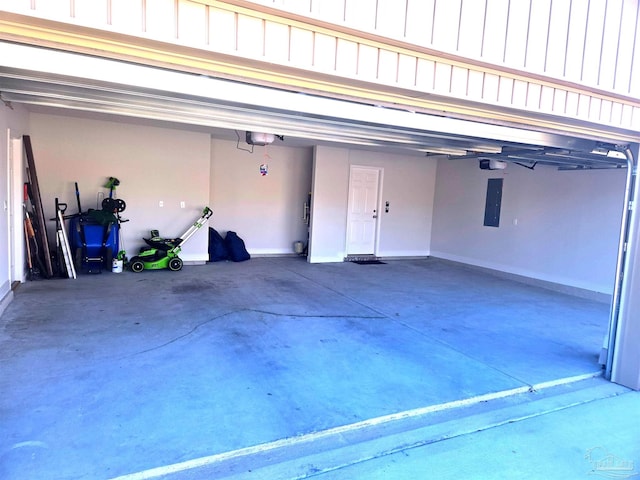 garage featuring a garage door opener, electric panel, and baseboards