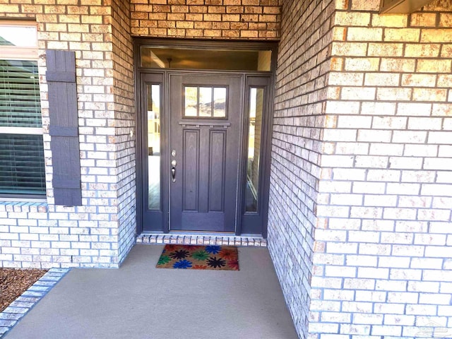 property entrance featuring brick siding