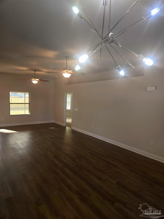 empty room featuring dark wood-type flooring and baseboards