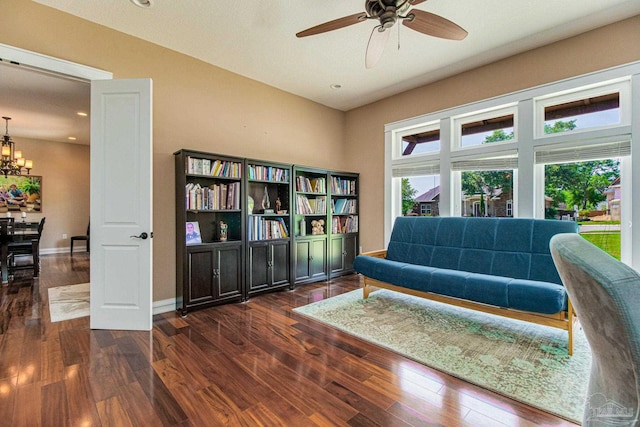 sitting room featuring dark hardwood / wood-style flooring and ceiling fan with notable chandelier