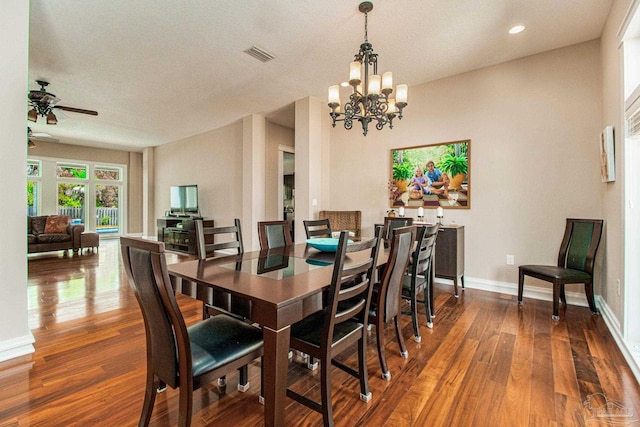 dining space with ceiling fan with notable chandelier and dark wood-type flooring