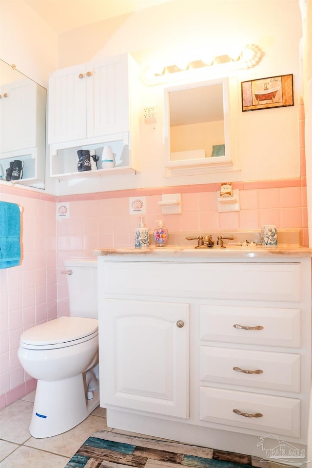 bathroom with vanity, toilet, tile patterned floors, and tile walls