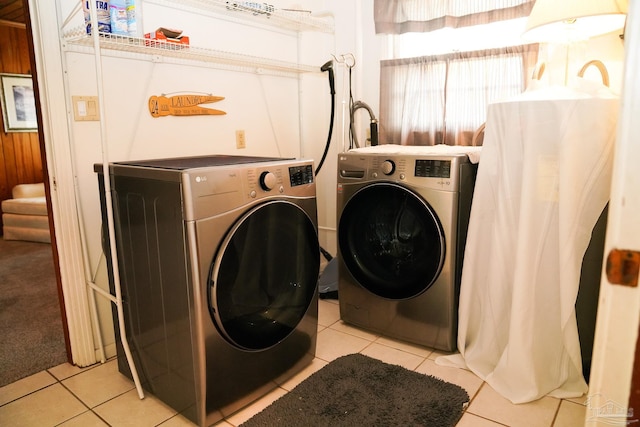 clothes washing area with light tile patterned floors and washer and clothes dryer