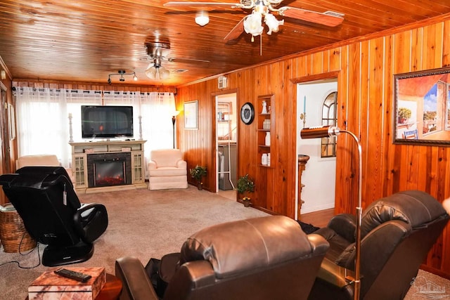 carpeted living room with ornamental molding, wooden walls, wood ceiling, and ceiling fan