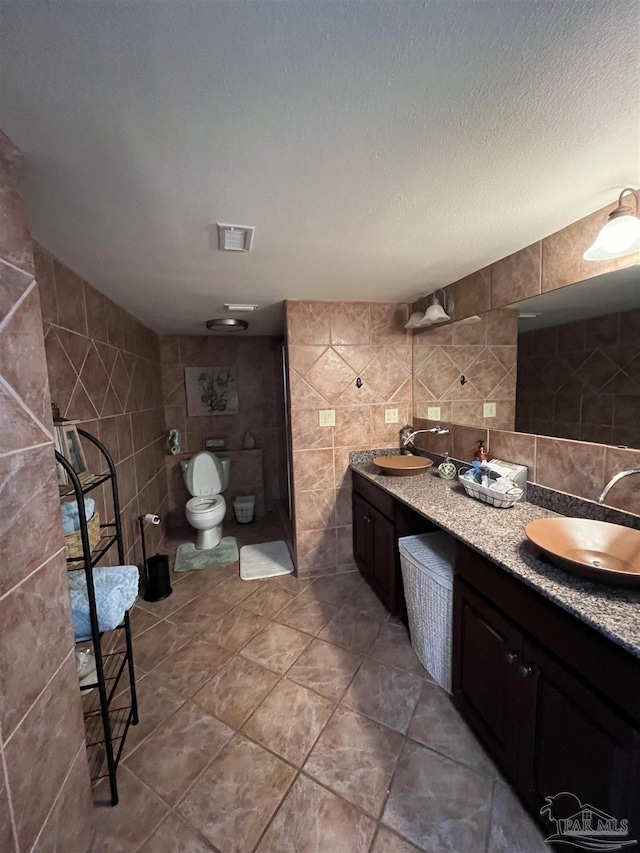 330FORT Pickens Rd Unit 11C, Pensacola Beach, FL 32561 - bathroom with a sink, tile walls, a textured ceiling, and double vanity