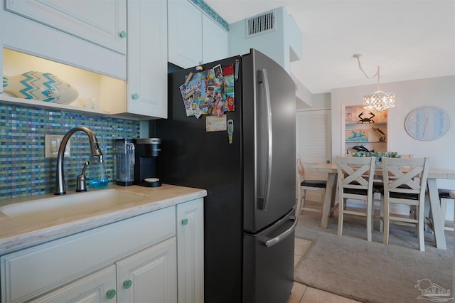330FORT Pickens Rd Unit 11C, Pensacola Beach, FL 32561 - kitchen featuring a sink, visible vents, white cabinets, freestanding refrigerator, and tasteful backsplash