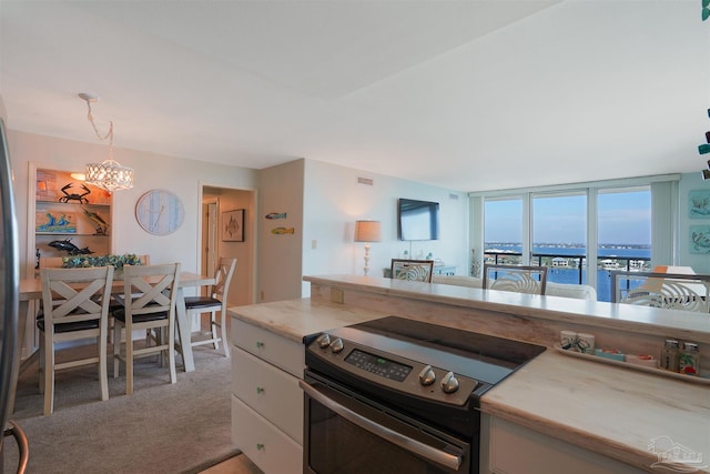330FORT Pickens Rd Unit 11C, Pensacola Beach, FL 32561 - kitchen featuring a chandelier, light colored carpet, light countertops, stainless steel electric range, and decorative light fixtures