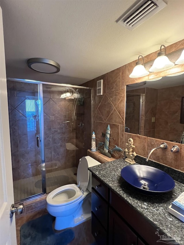 330FORT Pickens Rd Unit 11C, Pensacola Beach, FL 32561 - full bath featuring visible vents, decorative backsplash, toilet, a textured ceiling, and tile walls