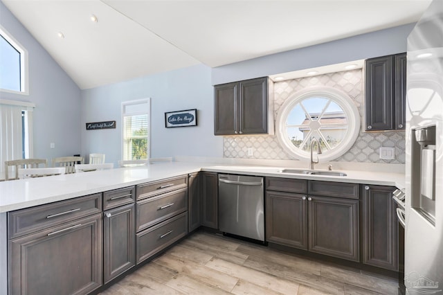 kitchen with sink, kitchen peninsula, stainless steel dishwasher, and decorative backsplash