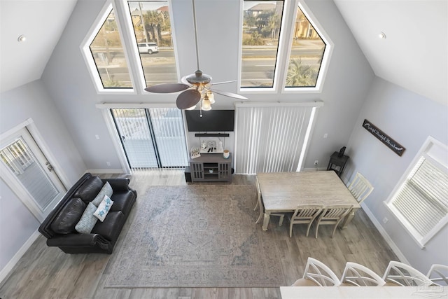 living room with a high ceiling, ceiling fan, and hardwood / wood-style floors