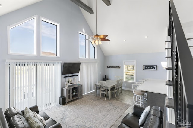 living room featuring hardwood / wood-style flooring, high vaulted ceiling, ceiling fan, and beamed ceiling