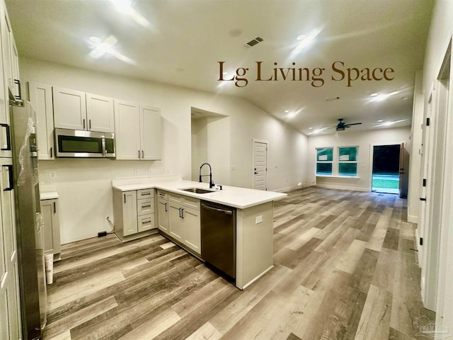 2020 Talbert St, Pensacola, FL 32507 - kitchen with stainless steel appliances, a sink, a peninsula, open floor plan, and light wood-style floors