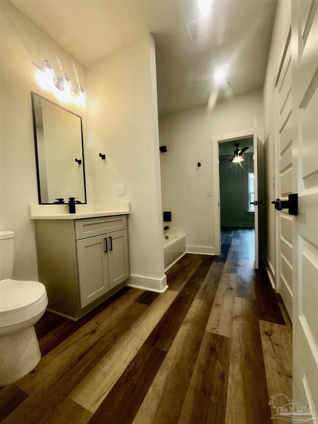 2020 Talbert St, Pensacola, FL 32507 - full bath featuring wood finished floors, toilet, a tub to relax in, vanity, and ceiling fan